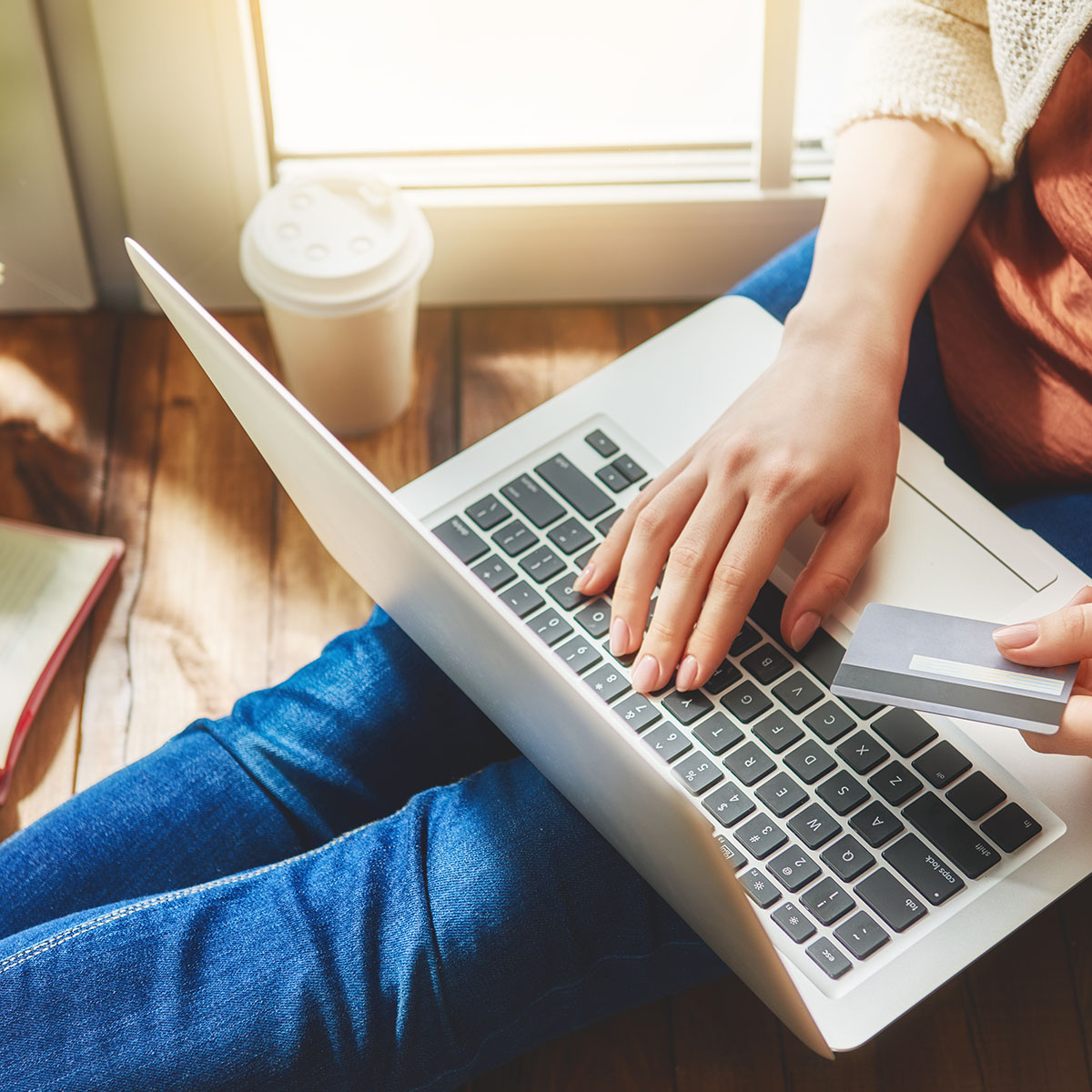 Woman is holding credit card and using laptop computer. Online shopping concept. Close up.