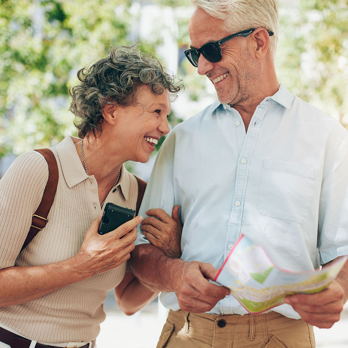 Retired couple walking around the town with a map. Smiling mature man and woman roaming around the city.