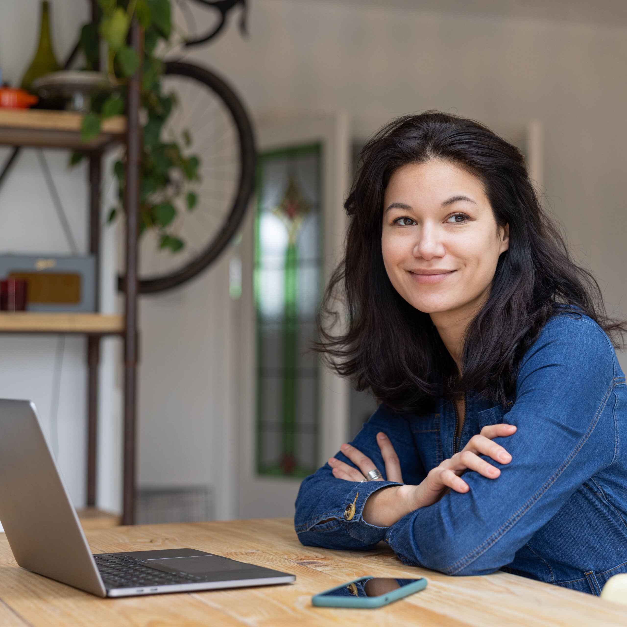 Mid adult asian female working on personal finances using a laptop and a smartphone