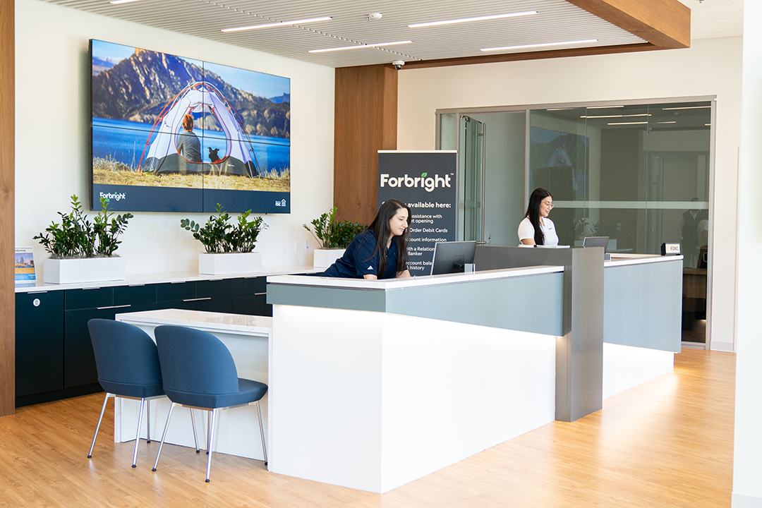 Two Forbright employees working at the front desk of a Forbright Service Hub