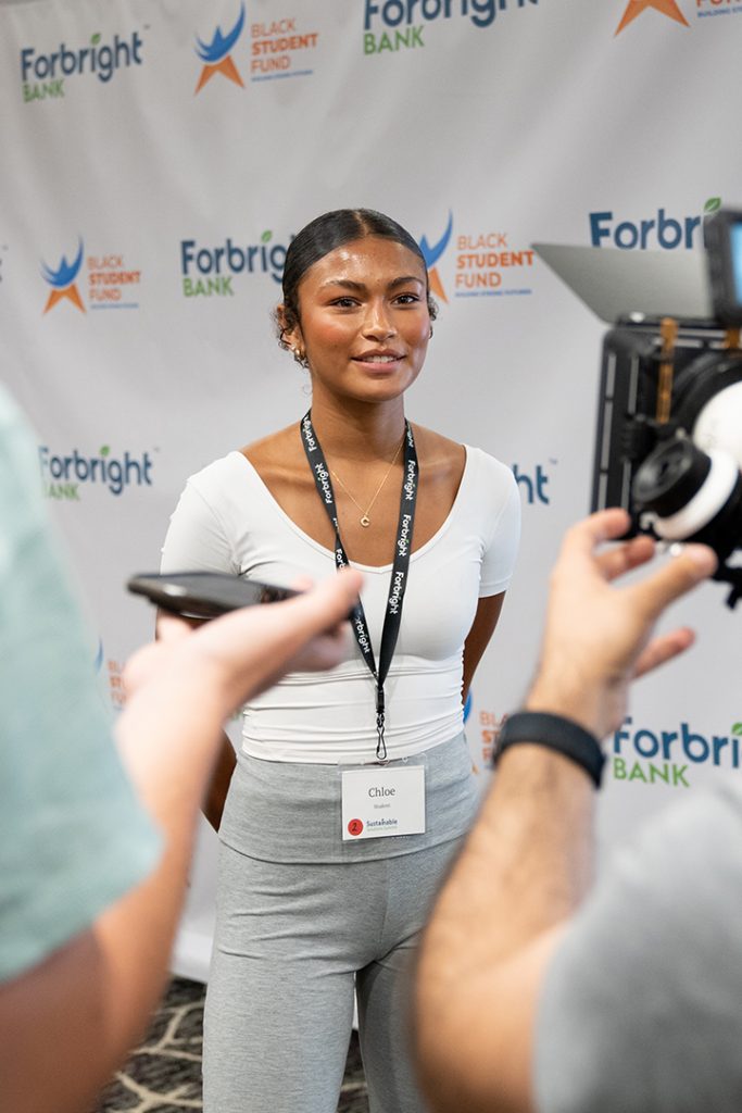 A young black woman is interviewed as a participant in the Forbright Bank 2024 Sustainable Solutions Summit